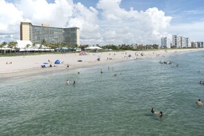 Ranta lähistöllä, aurinkotuoleja, rantapyyhkeitä