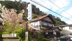 Un bâtiment traditionnel japonais, sur lequel on peut voir une enseigne indiquant qu’il s’agit d’un hôtel.