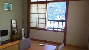 Une pièce de style japonais traditionnel, avec un sol recouvert de tatamis, une petite table en bois et une grande fenêtre à panneaux coulissants de type shoji.