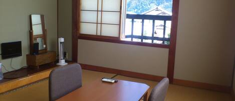 Een traditionele Japanse kamer met tatami vloerbedekking, een lage houten tafel en een groot shoji schuifvenster.