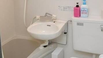 A compact bathroom with a bathtub, a sink, and a toilet.