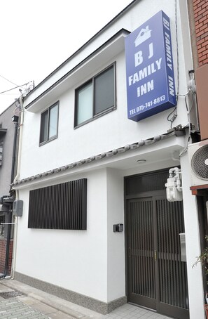 A two-story building with a sign for 'BJ Family Inn' and a contact number. - BJ Family Inn (Kyoto)
