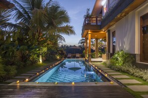 Una piscina al aire libre, sombrillas, tumbonas