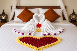 Een bed met een bloemen- en handdoekenopstelling in de vorm van een hart.