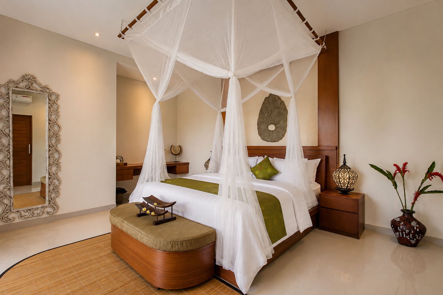 A hotel room with a four-poster bed, a bedside table with a lamp, a decorative mirror, and a small stool with a tray.