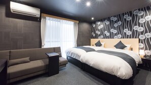 Une chambre d’hôtel moderne équipée d’un grand lit, d ’un canapé, d’une table de chevet et d’un appareil de climatisation.