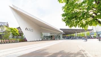 A modern building with a unique angular design, a covered entrance area, and a paved walkway.