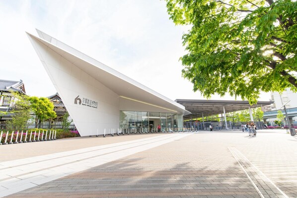 A modern building with a unique angular design, a covered entrance area, and a paved walkway.