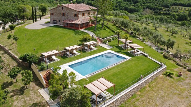 A stone villa with a swimming pool, surrounded by lush greenery and hills. - Podere Le Volte - Country House (Pergine Valdarno)