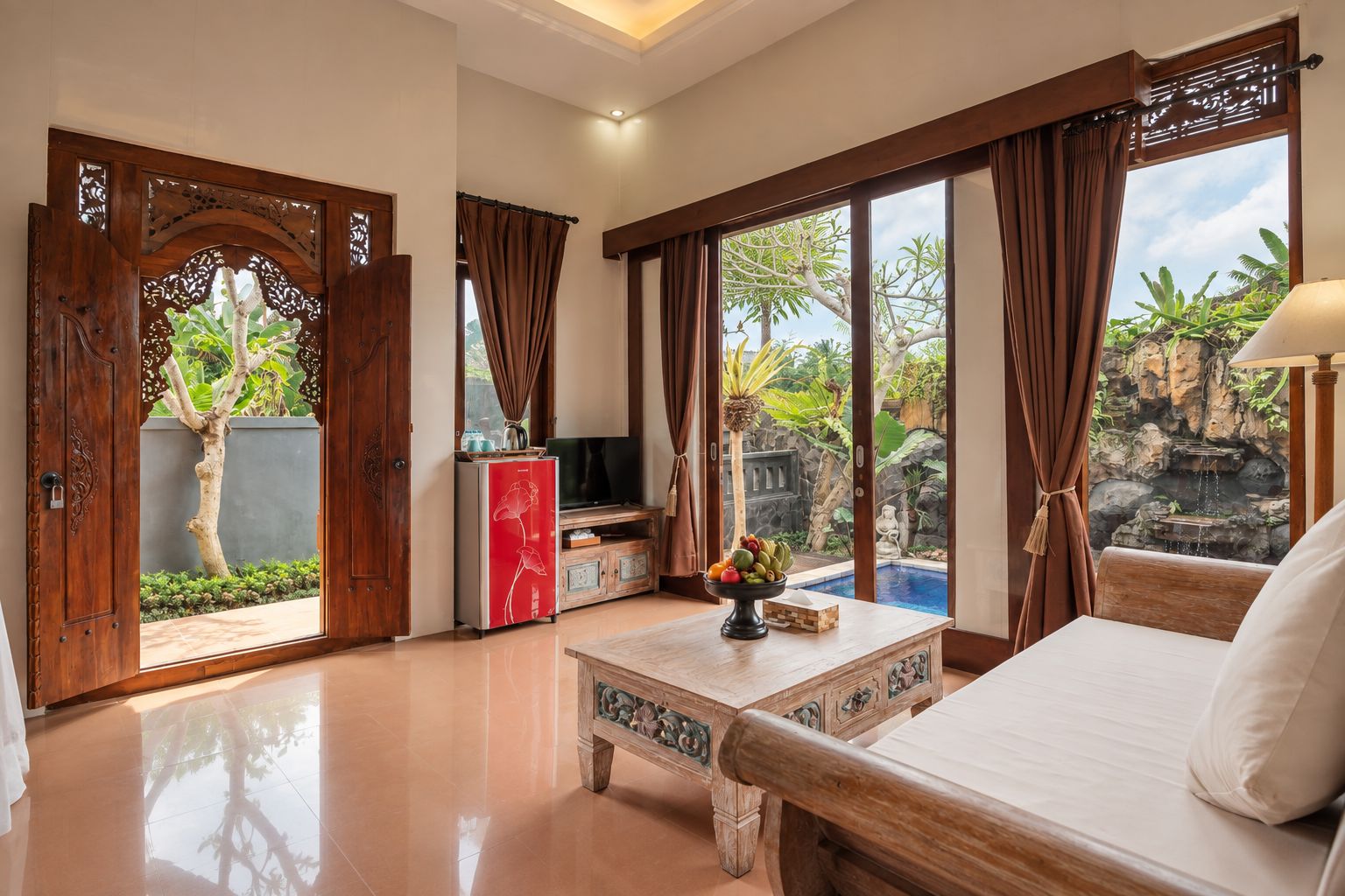 A spacious room with a bed, a TV, and a dining area.