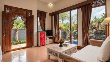 A spacious room with a bed, a TV, and a dining area.