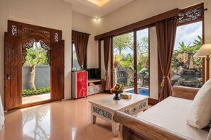 Una habitación amplia con una cama, un televisor y una zona de comedor.
