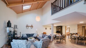 A spacious living area with a high ceiling, a dining area, and a kitchen. - O Cruceiro (Boiro)
