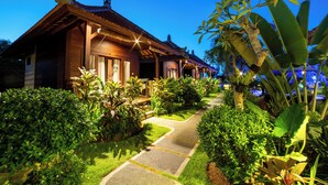 A traditional wooden building with a tiled roof, surrounded by lush greenery and a paved pathway. - D'Puncak Villas Lembongan (Lembongan Island)