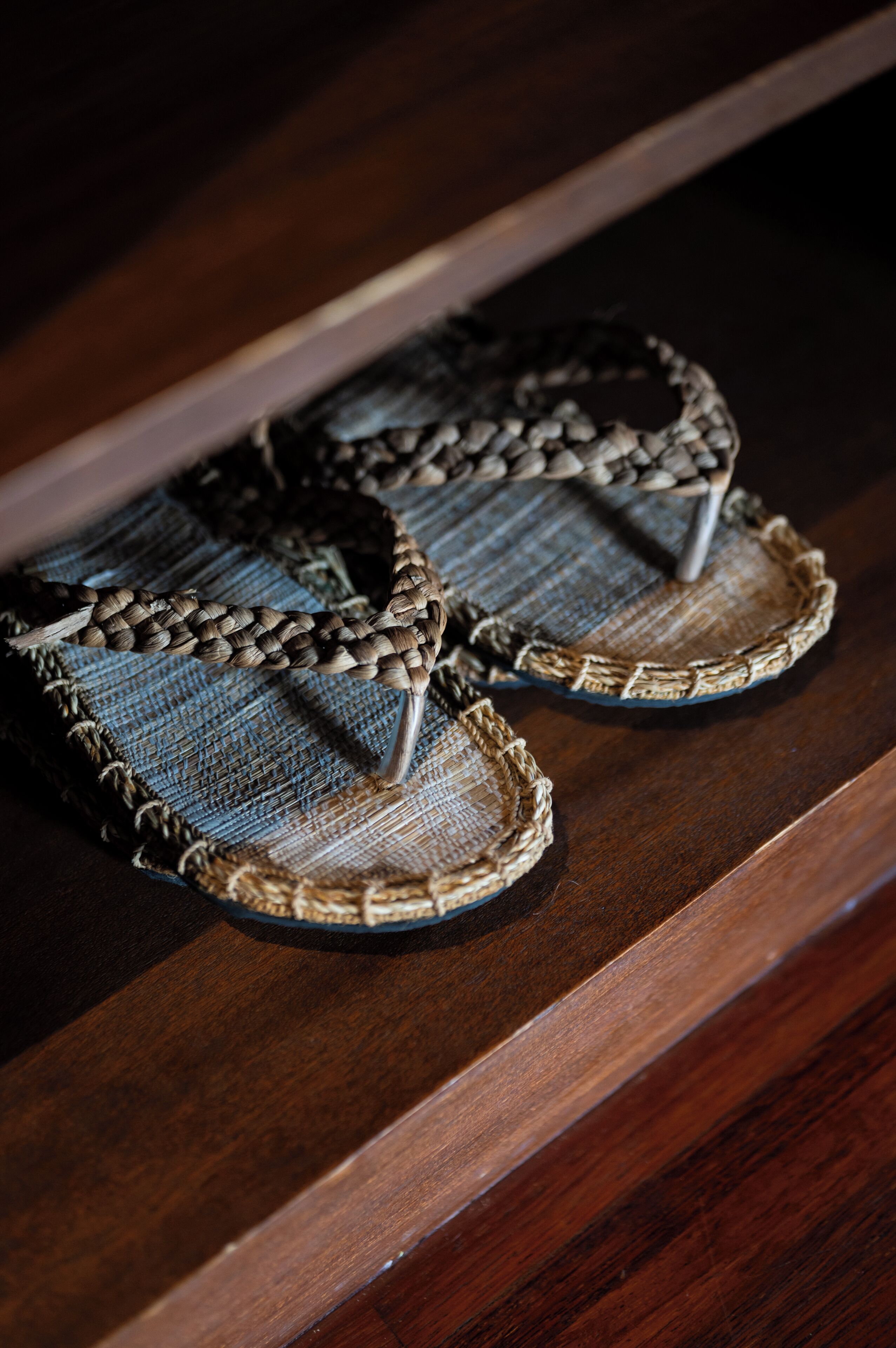 A pair of woven sandals on a wooden surface.