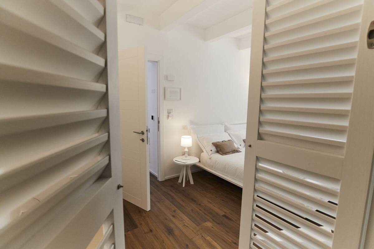 Un dormitorio con cama, mesita de noche y lámpara.