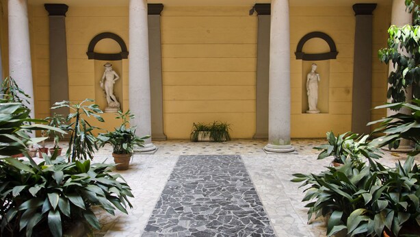 A courtyard with columns, statues, and potted plants. - Affittacamere Angel 2 (La Spezia)