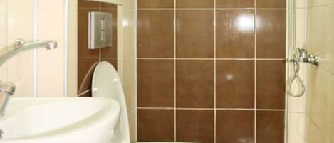 A bathroom with a toilet, sink, and shower.