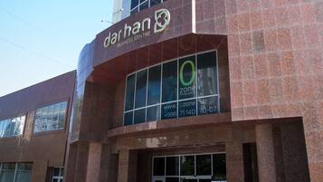 Un edificio moderno con una vasta facciata in vetro e un cartello con la scritta 'darhan business centre'.