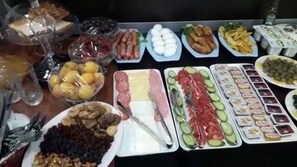 A buffet table with various food items including fruits, vegetables, meats, and cheeses. - Hotel 28 (Baku)