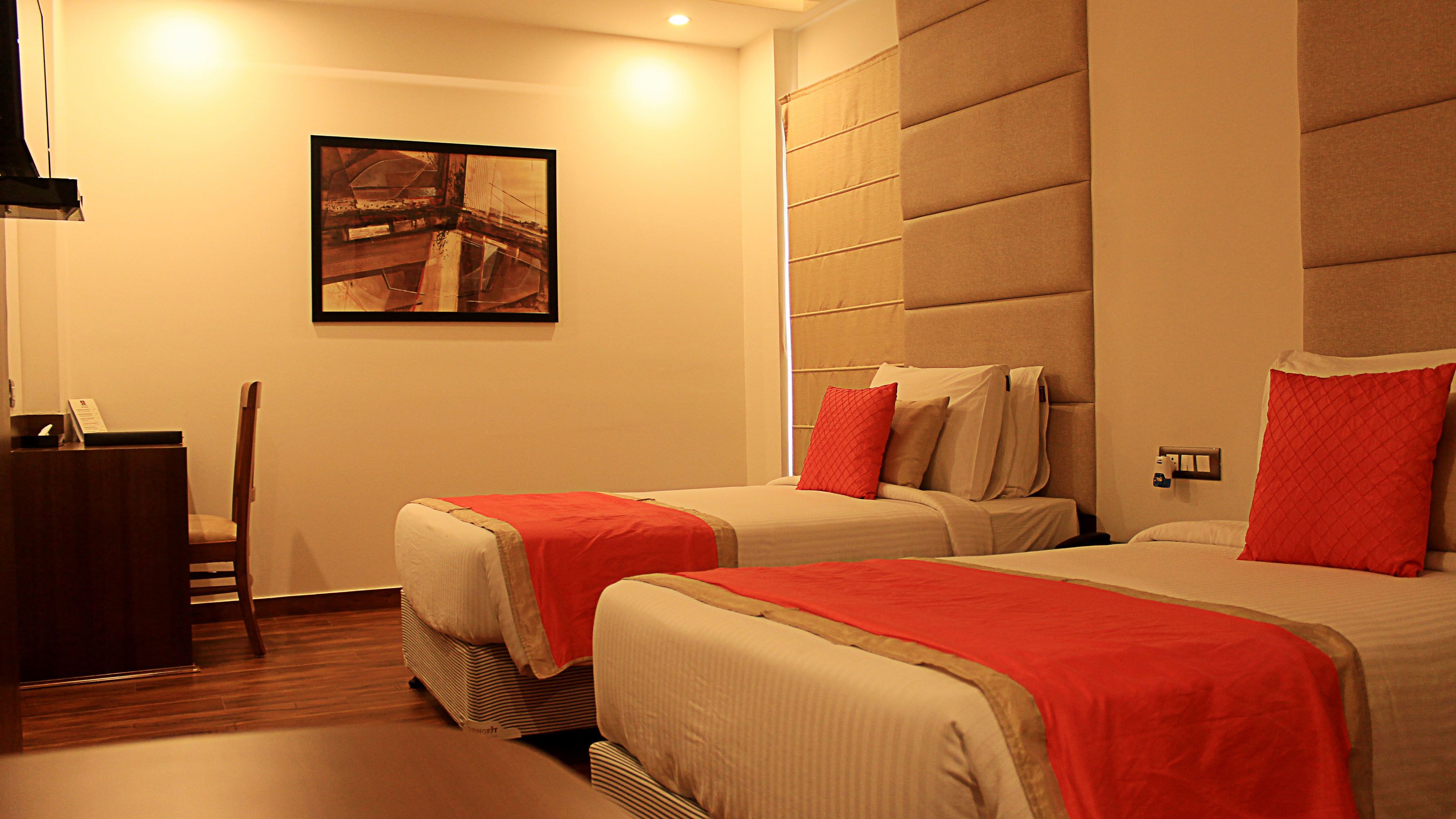 Una habitación de hotel con dos camas, un escritorio y una silla.