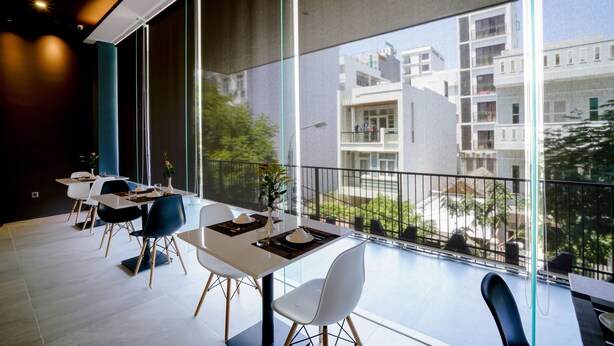 Un comedor moderno con balcón y vista a un edificio residencial.