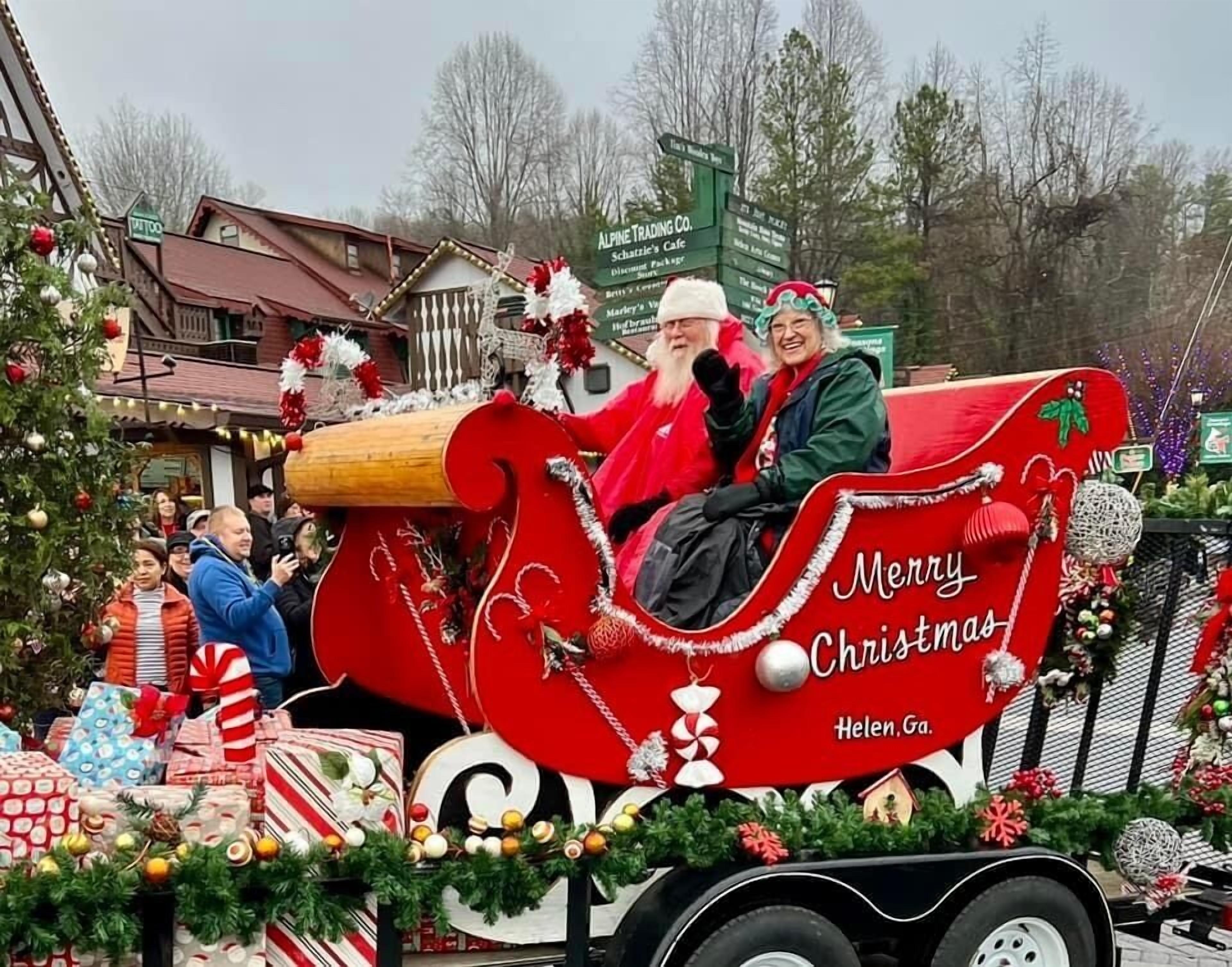 A festive scene with a decorated sleigh and a sign that reads "Merry Christmas" and "Helen, Ga."