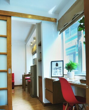 A compact hotel room with a kitchenette, a dining area, and a large window with a view.