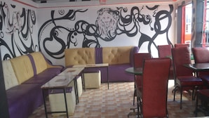 A restaurant with a checkered floor, a sofa, chairs, and a table. - Maendeleo Parkview Hotel (Narok)
