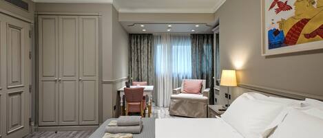 Una habitación de hotel con cama, escritorio, silla y armario.