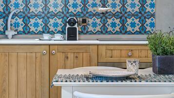 A kitchen with wooden cabinets, a patterned backsplash, a coffee maker, and a dining table with chairs.