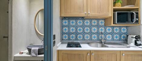 Una cucina compatta con mobili in legno, un forno a microonde e un backsplash decorato.