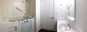 Bathroom features a shower, glass-enclosed tub, and separate sink area.