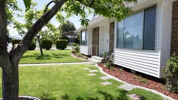 Stroll through the beautifully manicured front yard to the single-story house with a brick facade and large windows.