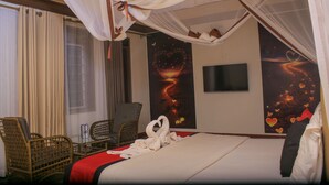 Une chambre d’hôtel avec un lit, une télévision, un bureau et une chaise.