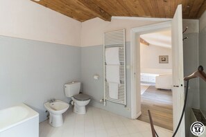 A bathroom with a toilet, bidet, and bathtub. - La Pasteliere (Gragnague)