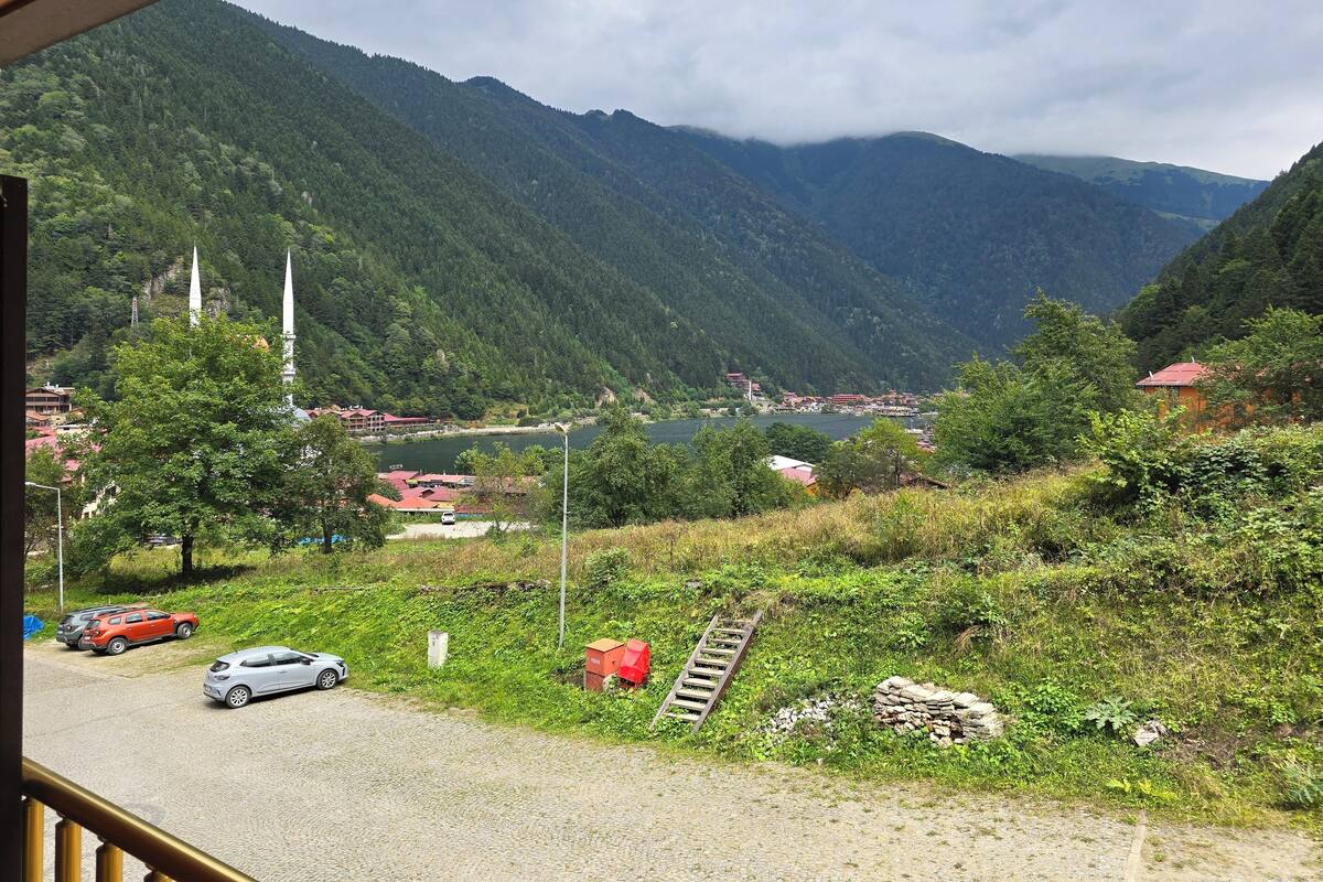 Eine Berglandschaft mit einem See, Gebäuden und einer Moschee.