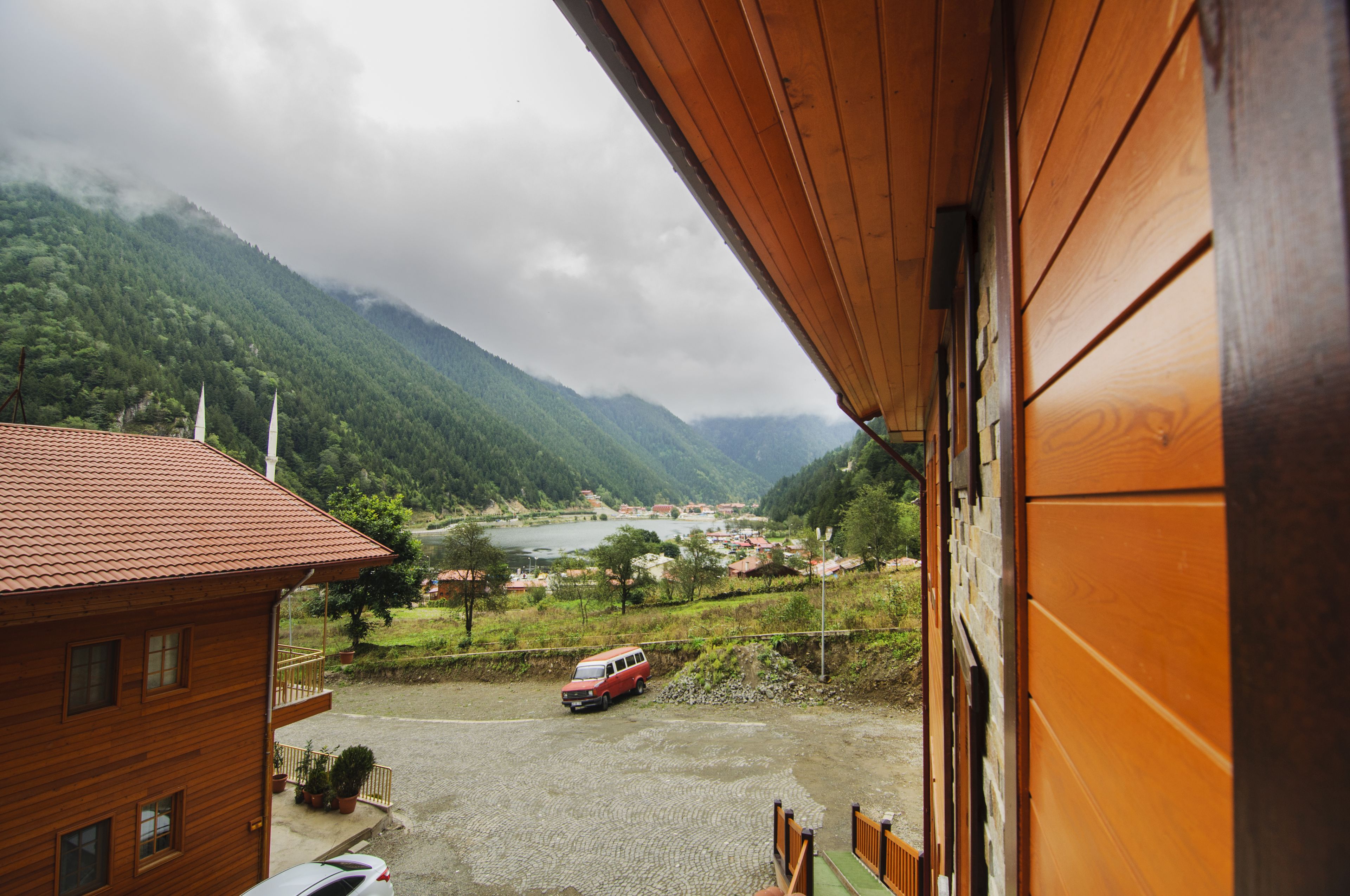 A wooden building with a view of a river and mountains in the background.