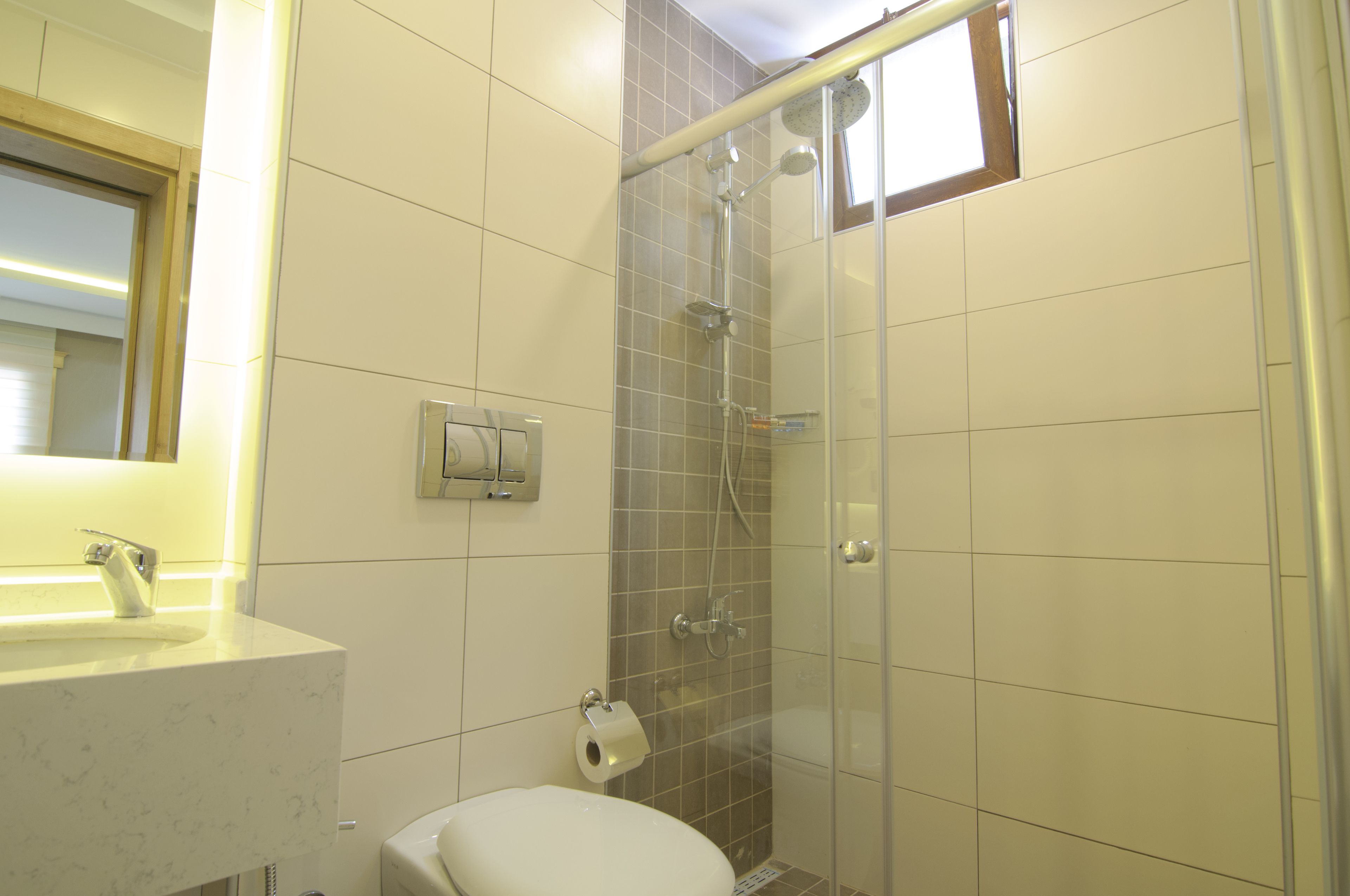 A bathroom with a toilet, sink, and shower.