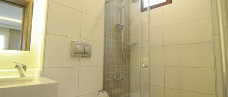 A bathroom with a toilet, sink, and shower.