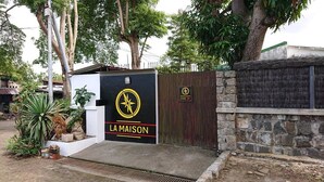 Una entrada tancada amb un rètol que diu "LA MAISON" i un símbol de brúixola.