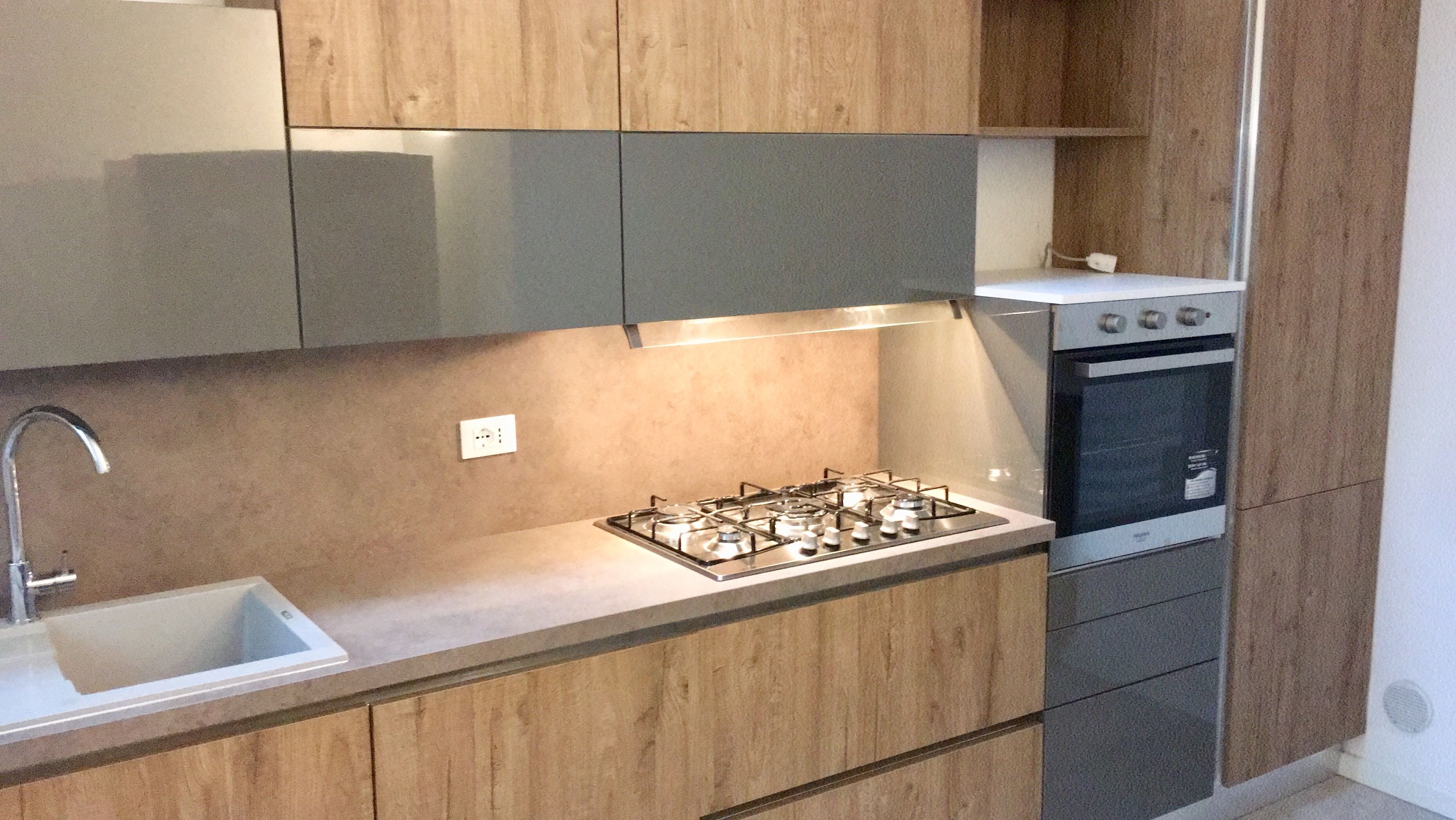 A modern kitchen with a gas stove, oven, and stainless steel sink.
