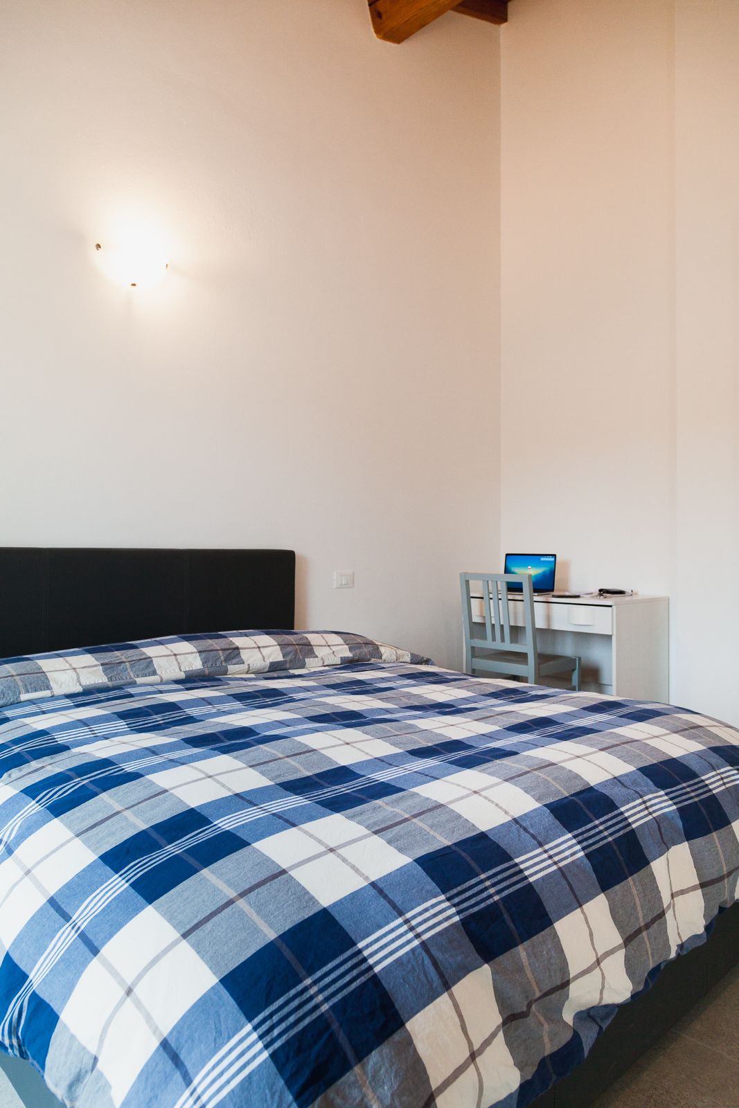 Un dormitorio con una cama, un escritorio y una silla.