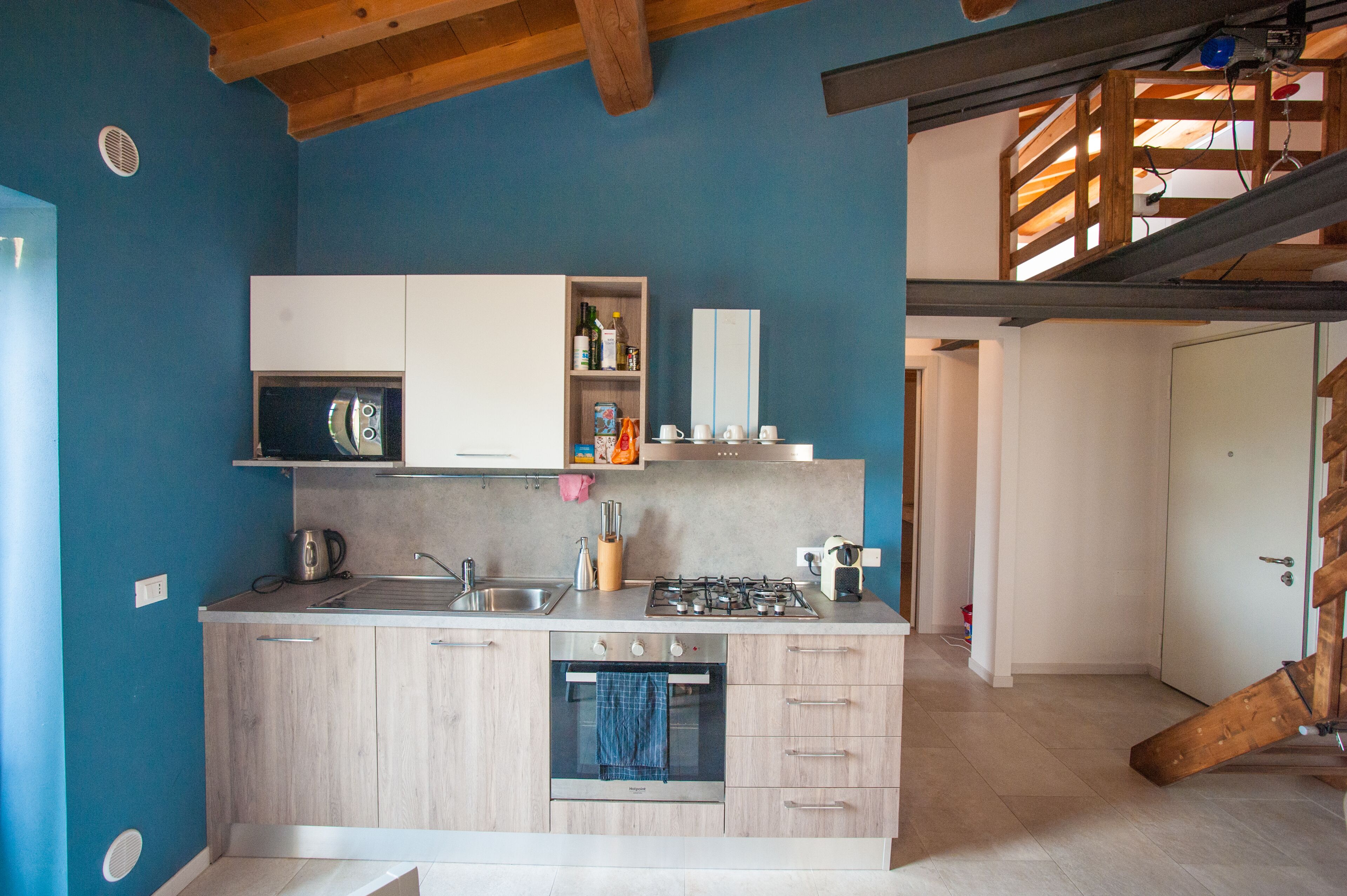 A compact kitchen with a built-in oven, a sink, and a gas stove.