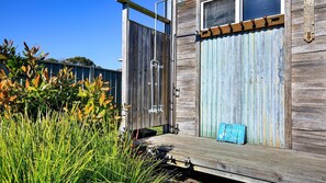 Escape to a serene retreat surrounded by lush greenery, with a wooden deck perfect for outdoor activities.