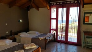 Un dormitorio con dos camas, techo de madera, ventana con cortinas rojas y vistas al exterior.