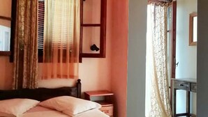 A bedroom with a bed, a bedside table, a mirror, and curtains. - 7 Seaview Studios 150 meters from the Sea + 6000 sq.m2 garden (14 to 19 persons) (Zakynthos)