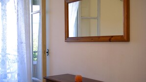 A room with a wooden dresser, a mirror on the wall, and a window with sheer curtains. - 7 Seaview Studios 150 meters from the Sea + 6000 sq.m2 garden (14 to 19 persons) (Zakynthos)