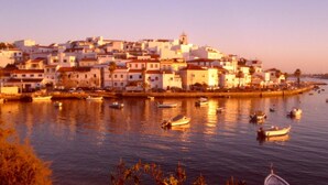 A coastal town with buildings along the waterfront, boats in the water, and a clear sky. - sunny ap. for 2-6 people, exclusive 1a location directly on the beach by the sea (Ferragudo)