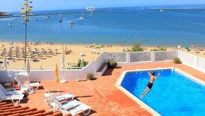 A pool area with a view of the beach and ocean. - sunny ap. for 2-6 people, exclusive 1a location directly on the beach by the sea (Ferragudo)